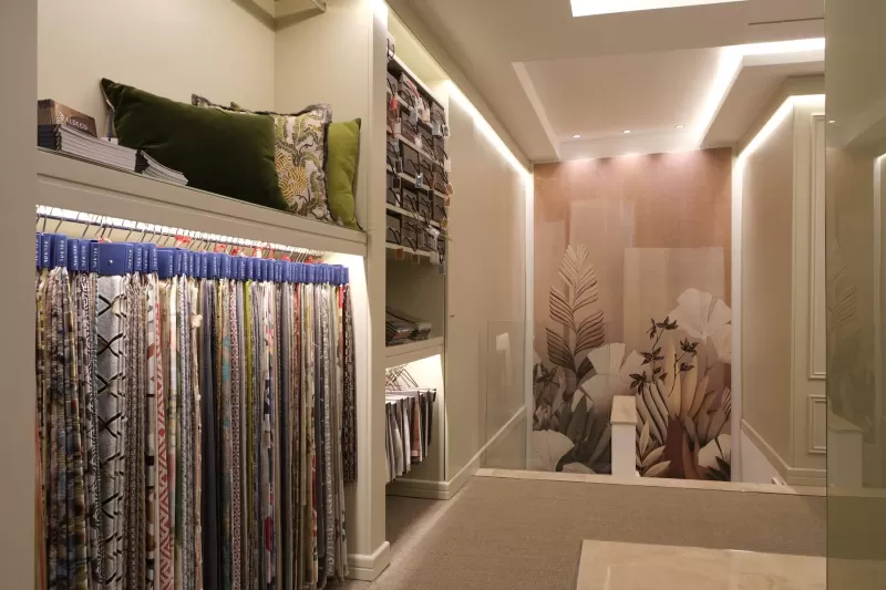 A wall of fabric samples beside a botanical mural