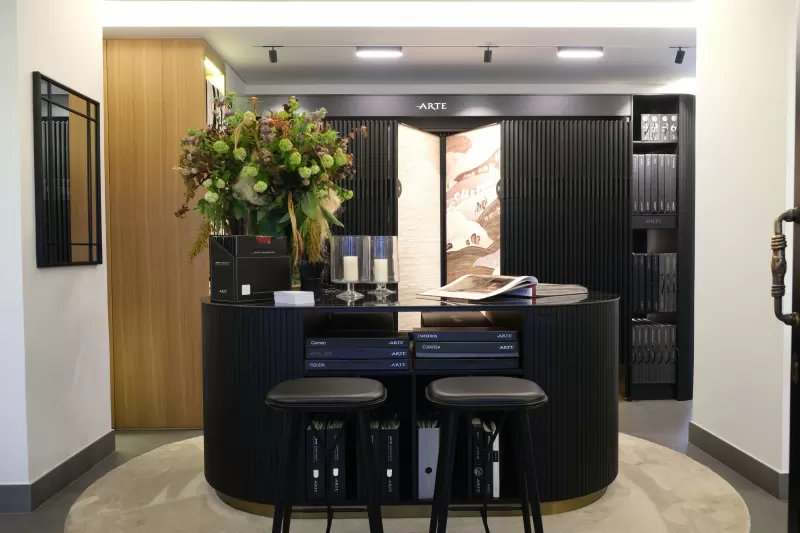 The reception desk with a sample-book wall behind it